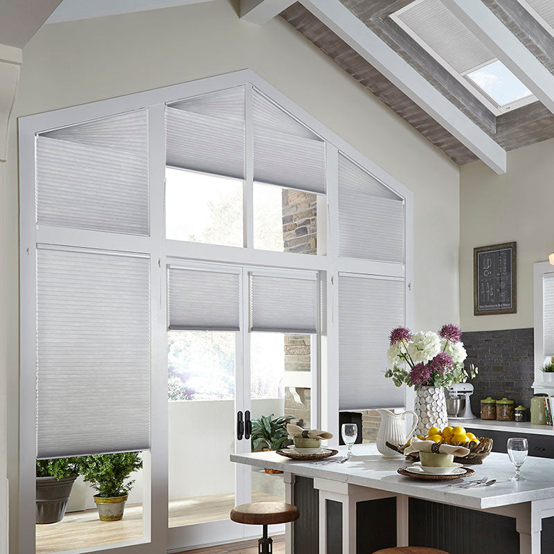 kitchen with beige walls and white window trim, wall of large windows of odd shapes and sized covered with customizable window treatments from Regal Paint Centers, designed for energy efficiency
