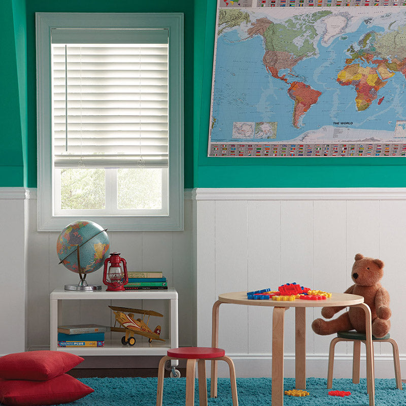 kids playroom with aqua green walls and white wainscoting, window with child and pet safe window blind.